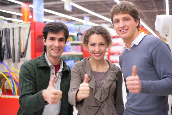 Tre vänner göra gest ok i butik — Stockfoto