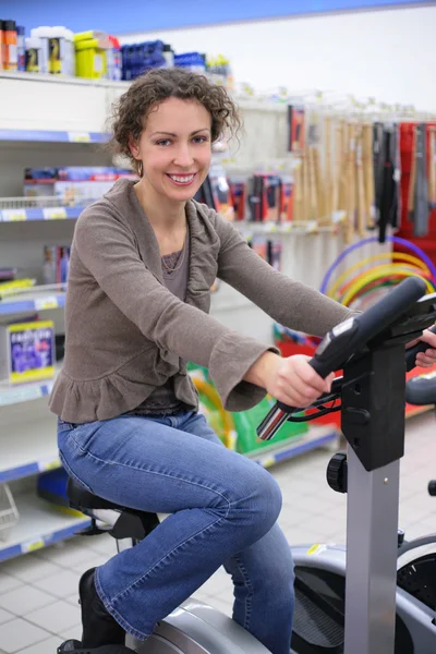 Giovane donna su attrezzature sportive di formazione in negozio — Foto Stock