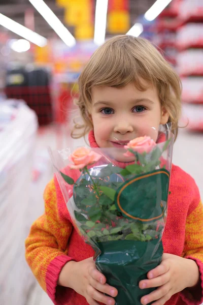 Criança segura panela com flor na loja — Fotografia de Stock