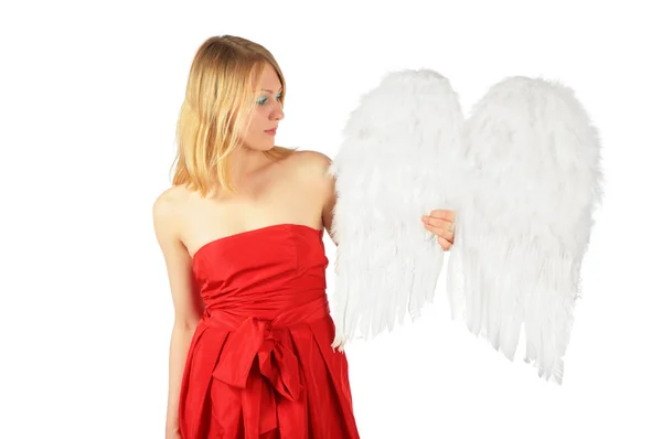 Menina loira em vestido vermelho segura asas de anjo — Fotografia de Stock
