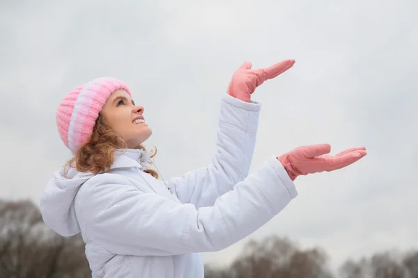 Молодая красавица на свежем воздухе зимой ловит снежинки — стоковое фото