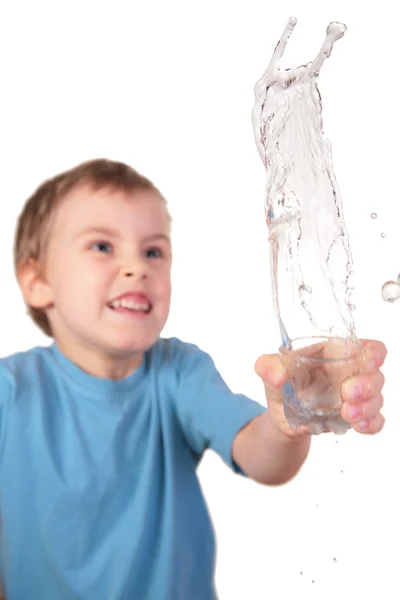 Boy spills water from glass — Stock Photo, Image