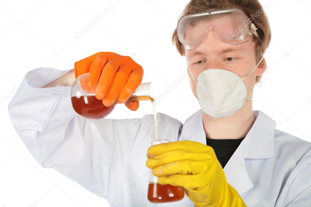 Scientist in respirator and rubber gloves pours brown liquid fr