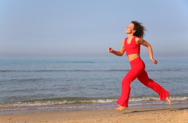 Young woman runs on shore of sea clipart