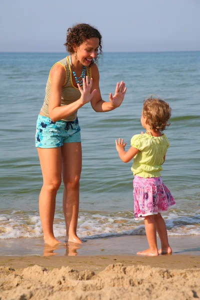 Mother plays with daughter on beach — Stock Photo, Image