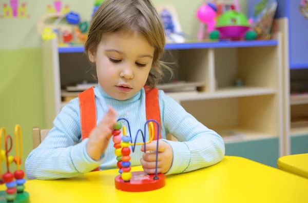 Маленькая девочка играет в детском саду — стоковое фото