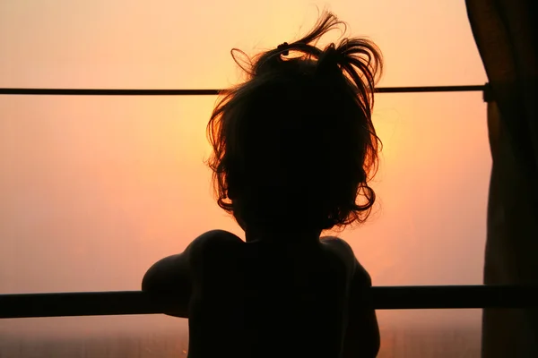 Silhouette of child in window of train — Stock Photo, Image
