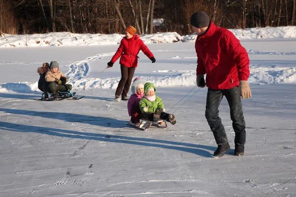 Parents pull children on sleds — Stock Photo, Image