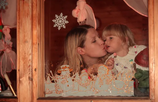 Mutter hinter Fenster küsst Tochter — Stockfoto