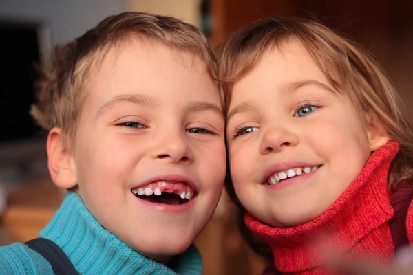 Lachender Junge ohne Vorderzähne und lächelndes Mädchen — Stockfoto