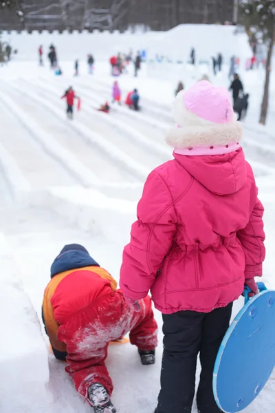 Kinderen op ijs helling in park — Stockfoto
