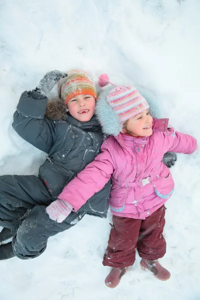 Children lying on snow — Stock Photo, Image