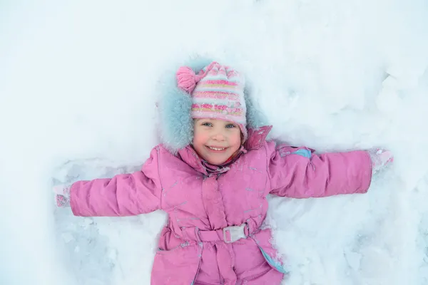 Μικρό κορίτσι ξαπλωμένο στο χιόνι — Φωτογραφία Αρχείου