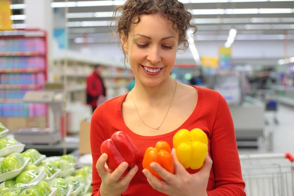 Young woman in shop with sweet peppers — Stock Photo, Image