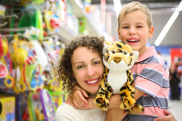 Mãe e filho com brinquedo macio na loja — Fotografia de Stock