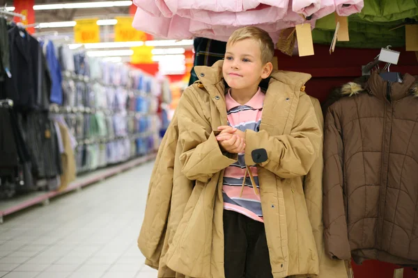 Pojke försöker på jacka i butik — Stockfoto