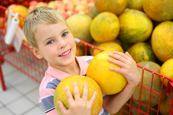 Pojke med meloner i butik — Stockfoto