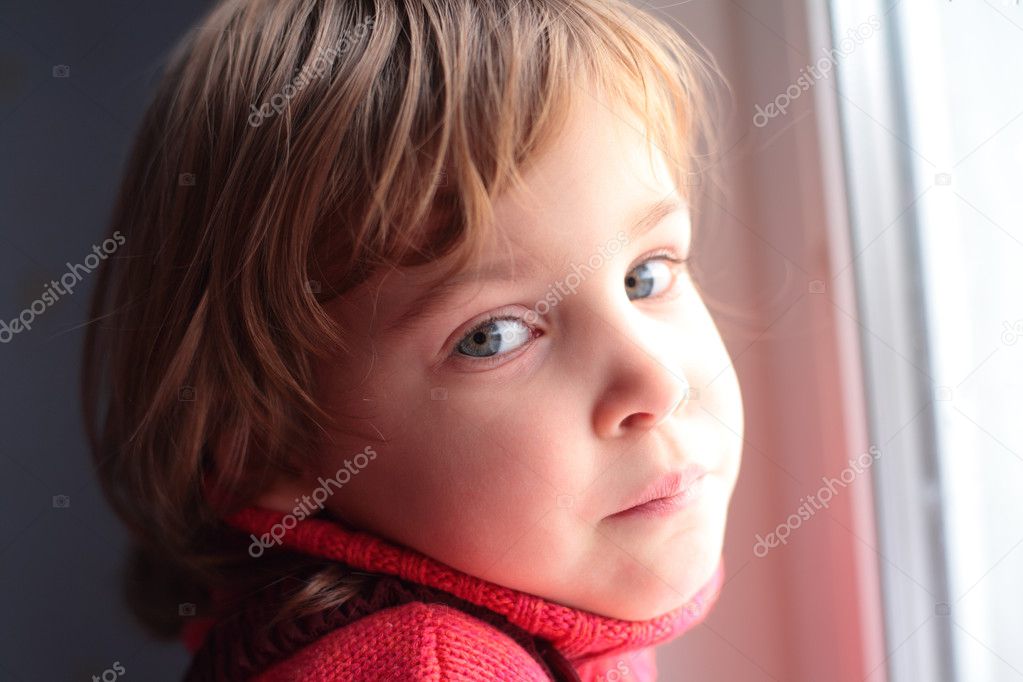 Little thoughtful girl at window