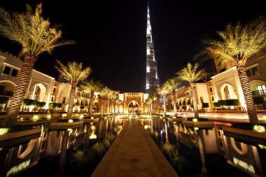 Burj Dubai, night Dubai street with palms and pool general view,