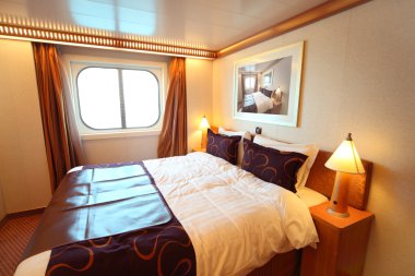 Ship cabin with big double bed and window summer day clipart