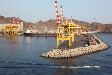 Yellow cranes in shipping port near mountains summer day clipart