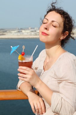 Beauty brunette woman in white shirt standing on cruise liner de clipart