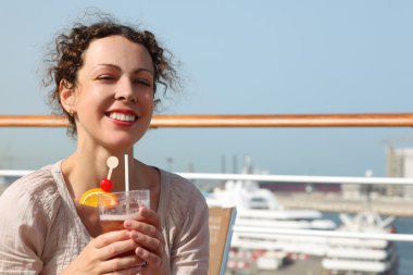 Beauty brunette woman in white shirt standing on cruise liner de clipart