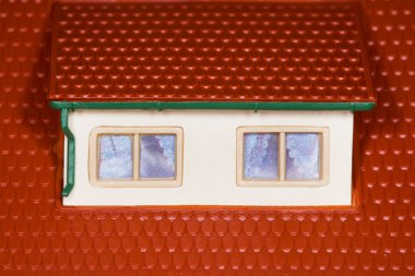 Attic on roof of toy plastic house,two windows clipart