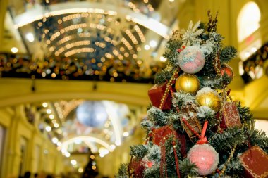 Fur-tree densely covered by Christmas ornaments in shopping cent clipart