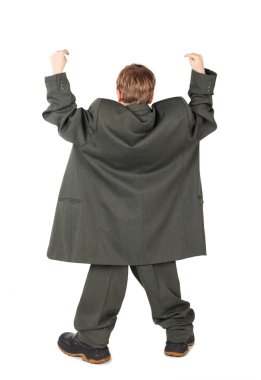 Little boy in big grey man's suit and boots hand view from back clipart