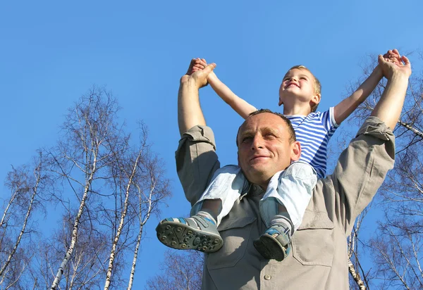 Senior with child on shoulders in front of spring birch tree col — Stock Photo, Image