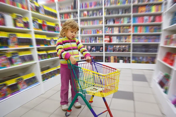 Klein meisje in de boekhandel — Stockfoto
