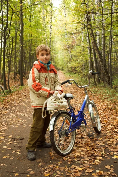 Menino de jaqueta está no parque infantil no outono — Fotografia de Stock