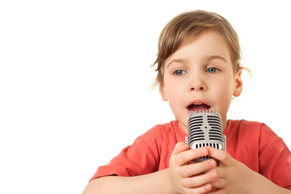 Pretty little girl in red sing in old style microphone isolated — Stock Photo, Image
