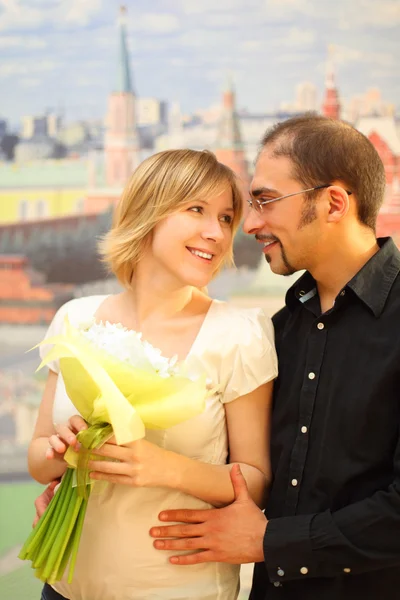 Man in glasses embracing beauty blond girl with flowers bouquet, — Stock Photo, Image