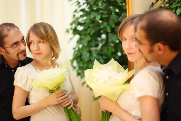 Uomo in occhiali e bellezza ragazza bionda con fiori bouquet standi — Foto Stock