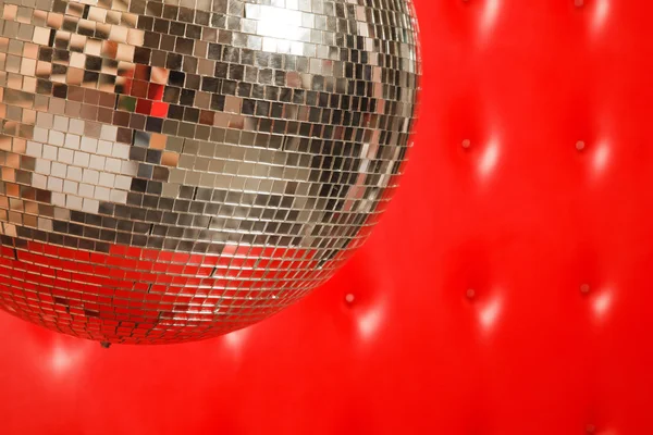 Taneční zrcadlová koule na pozadí červené kožené — Stock fotografie