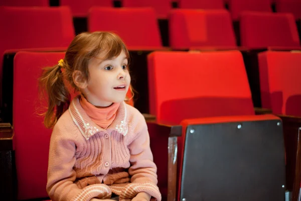 Smiling little girl sitting on armchairs at cinema — Stock Photo, Image