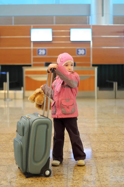 Kleines Mädchen mit grauem Koffer steht allein am Flughafen — Stockfoto