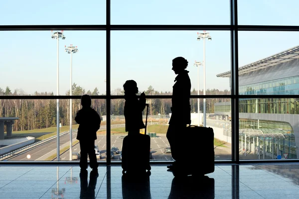 Silhouette of mother, son and daughter with luggage standing nea — Stock Photo, Image
