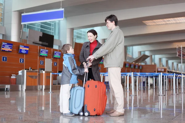 Young family with boy standing in airport hall with suitcases si — Stock Photo, Image