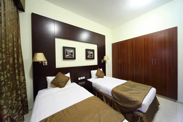 Dormitorio con paredes blancas, armario y dos camas vista general — Foto de Stock