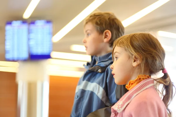 Menino e menina no aeroporto telas azuis no fundo lado v — Fotografia de Stock