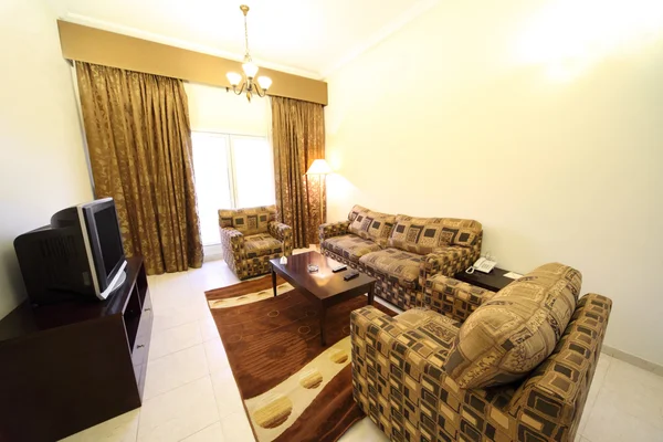 Гостиная с коричневым диваном, креслами и телевизионным занавесом — стоковое фото