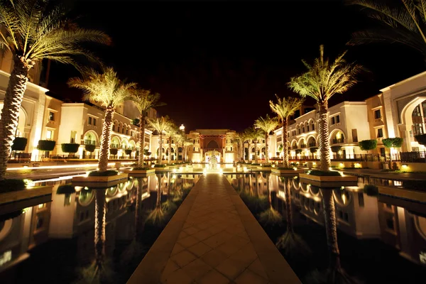 Ночная улица Дубая с пальмами и видом на бассейн, Объединенные Арабские Эмираты — стоковое фото