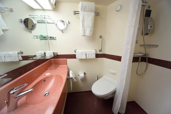 Современная ванная комната с белыми стенами и красной раковиной и зеркалом в Crui — стоковое фото