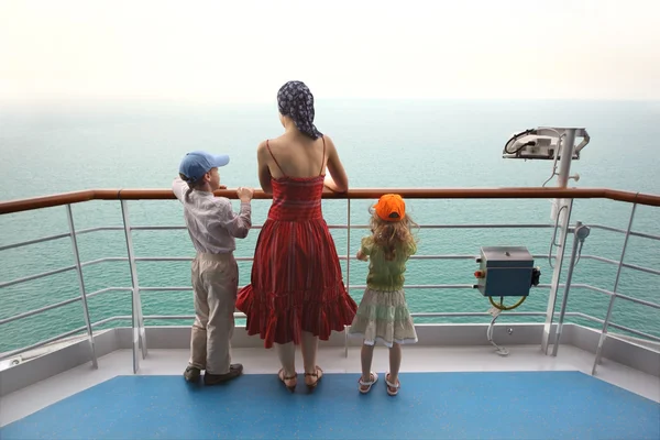 Мальчик и девочка с матерью стоят на палубе корабля и смотрят — стоковое фото