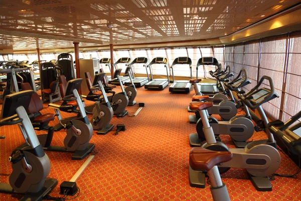 Grote fitnessruimte een gezellige ontvangsthal met loopbanden en uitoefening fiets in cruise sh — Stockfoto