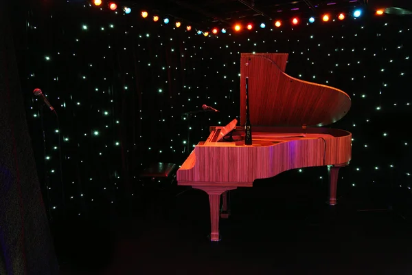Piano de cauda em palco de concerto com cortinas pretas decored multicol — Fotografia de Stock