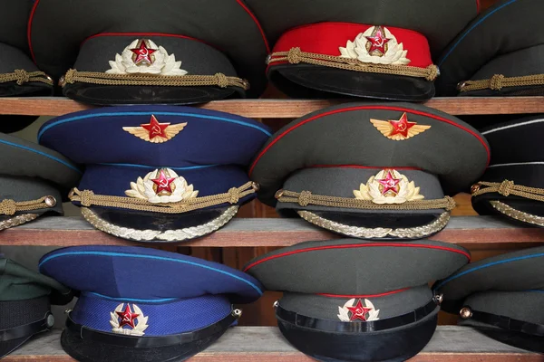 Sombreros uniformes Ussr polisman con visera en estante de madera —  Fotos de Stock